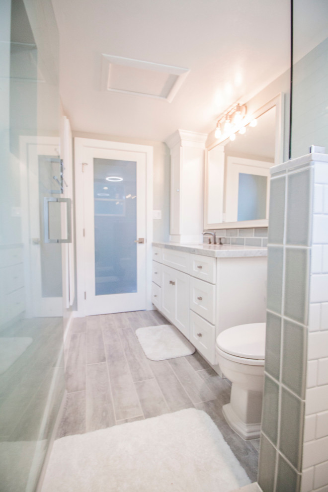 Inspiration för små moderna badrum med dusch, med skåp i shakerstil, vita skåp, en dusch i en alkov, en toalettstol med hel cisternkåpa, blå kakel, glaskakel, blå väggar, klinkergolv i porslin, ett undermonterad handfat och marmorbänkskiva