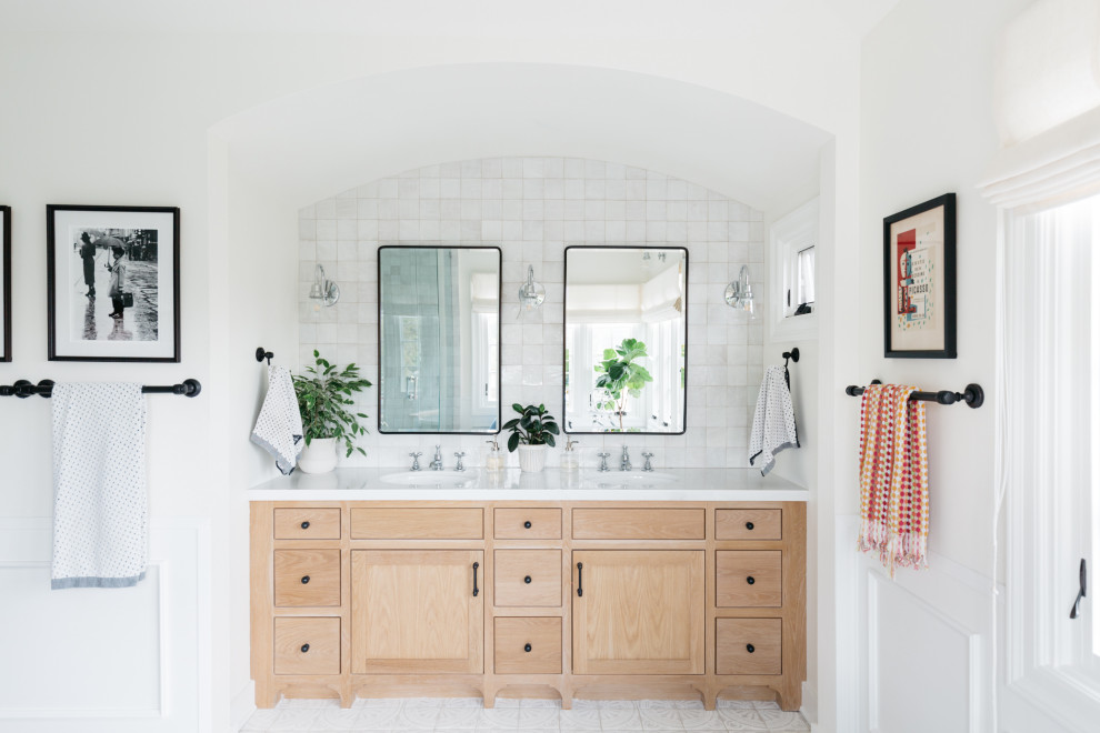 Klassisches Badezimmer mit flächenbündigen Schrankfronten, beigen Schränken, weißen Fliesen, weißer Wandfarbe, Unterbauwaschbecken, weißem Boden, weißer Waschtischplatte und Doppelwaschbecken in Los Angeles