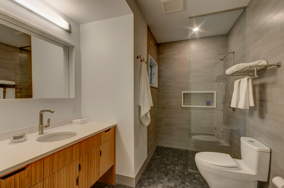 Walk-in shower - mid-sized contemporary master gray tile and porcelain tile slate floor walk-in shower idea in Portland with an undermount sink, flat-panel cabinets, medium tone wood cabinets, quartz countertops, a one-piece toilet and white walls