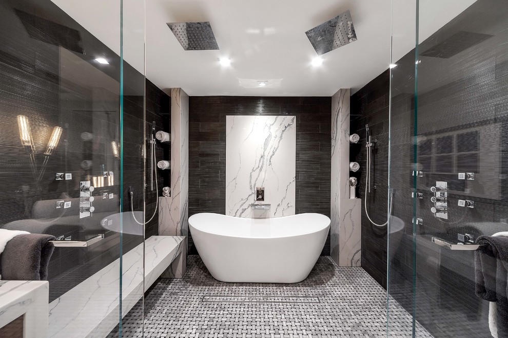 Foto på ett stort funkis vit en-suite badrum, med släta luckor, skåp i mellenmörkt trä, ett fristående badkar, en kantlös dusch, grå väggar, grå kakel, mosaikgolv, grått golv och med dusch som är öppen