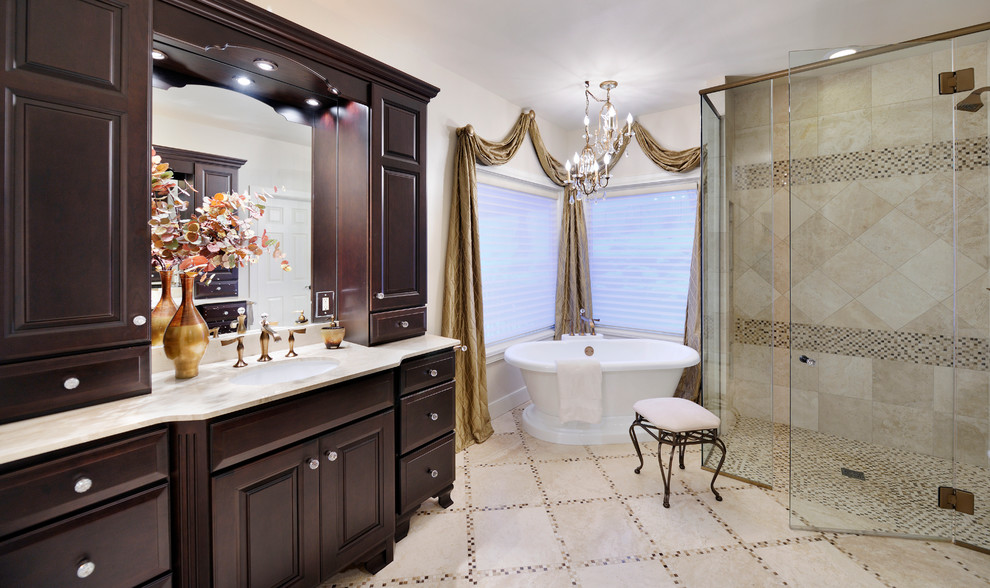 Inspiration for a mid-sized timeless master multicolored tile and stone tile travertine floor bathroom remodel in St Louis with an undermount sink, dark wood cabinets, marble countertops, beige walls and raised-panel cabinets