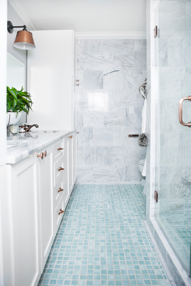 На фото: главная ванная комната среднего размера в стиле неоклассика (современная классика) с белыми фасадами, угловым душем, серой плиткой, мраморной плиткой, серыми стенами, полом из мозаичной плитки, мраморной столешницей, синим полом и душем с распашными дверями