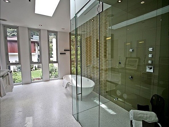 На фото: главная ванная комната среднего размера в современном стиле с плоскими фасадами, белыми фасадами, отдельно стоящей ванной, душем в нише, бежевой плиткой, зеленой плиткой, плиткой из листового стекла, разноцветными стенами, полом из керамической плитки, врезной раковиной, столешницей из искусственного камня, белым полом и душем с распашными дверями