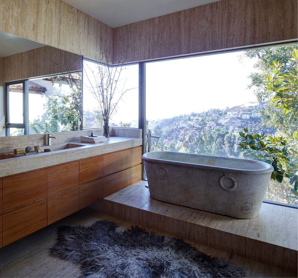 Foto di una stanza da bagno contemporanea con vasca freestanding, ante lisce, ante in legno scuro, piastrelle beige, pareti beige, lavabo integrato, pavimento beige e top beige