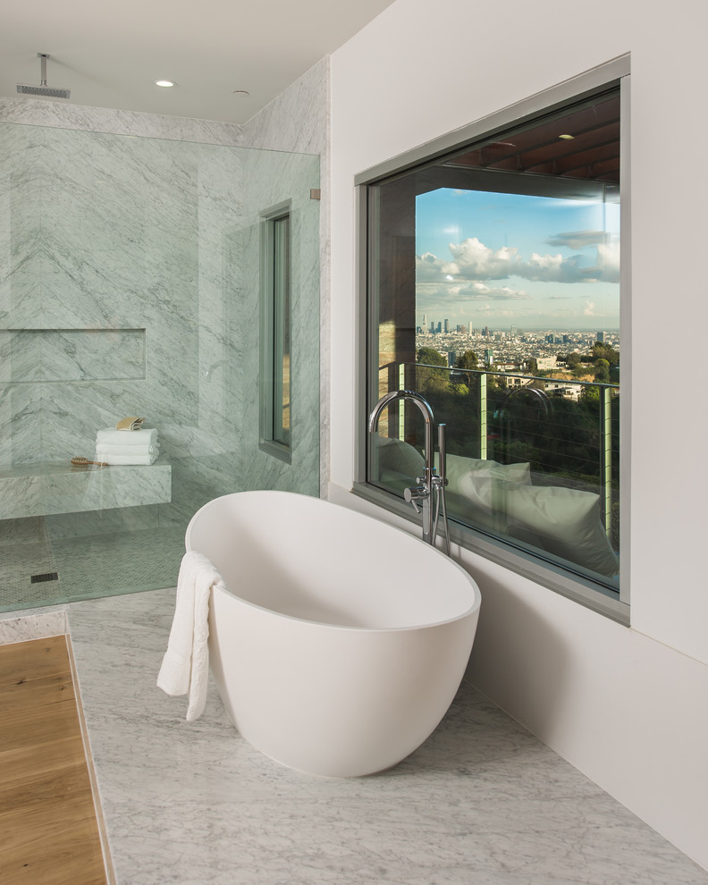 Esempio di una stanza da bagno padronale design di medie dimensioni con vasca freestanding, doccia aperta, piastrelle grigie, piastrelle bianche, lastra di pietra, pareti bianche e parquet chiaro
