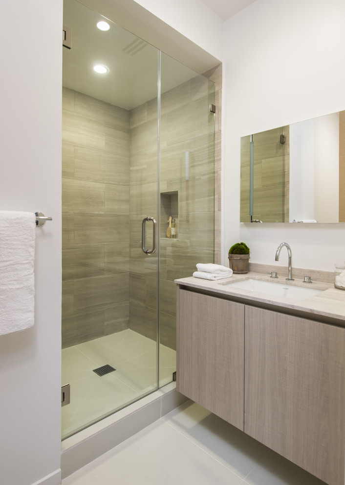 ロサンゼルスにあるラグジュアリーな小さなコンテンポラリースタイルのおしゃれなバスルーム (浴槽なし) (アンダーカウンター洗面器、フラットパネル扉のキャビネット、グレーのキャビネット、大理石の洗面台、アルコーブ型シャワー、グレーのタイル、セラミックタイル、白い壁) の写真