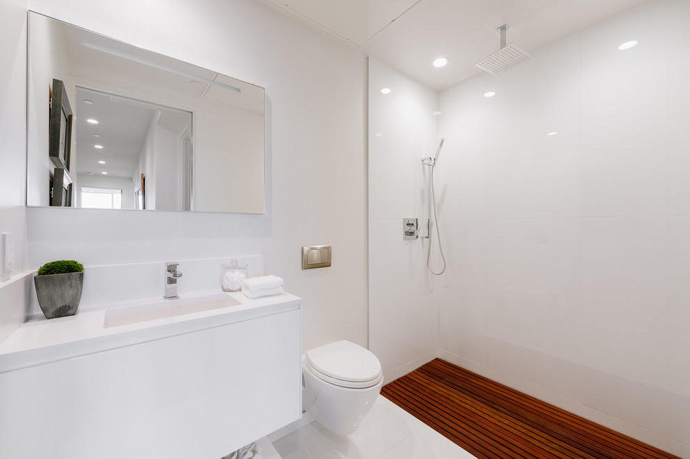 Photo of a small modern bathroom in Los Angeles with a wall mounted toilet, an integrated sink, solid surface worktops, an open shower and white worktops.