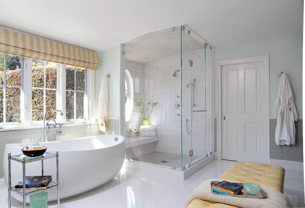 На фото: главная ванная комната в стиле неоклассика (современная классика) с отдельно стоящей ванной, угловым душем, белой плиткой, керамической плиткой, серыми стенами, белым полом и душем с распашными дверями