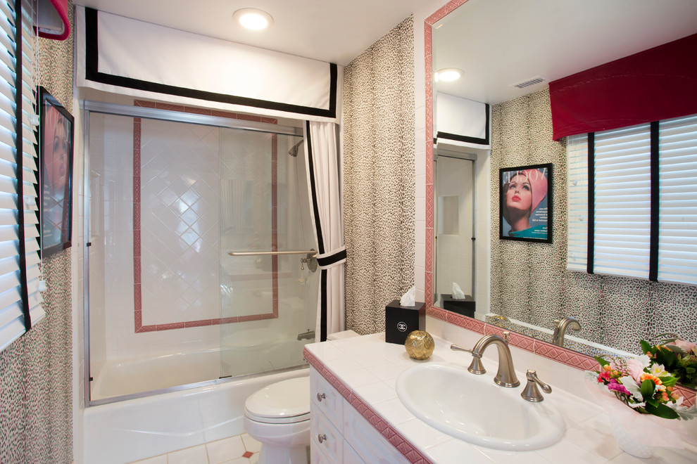 Foto på ett mellanstort eklektiskt badrum med dusch, med luckor med upphöjd panel, vita skåp, ett badkar i en alkov, en dusch/badkar-kombination, en toalettstol med separat cisternkåpa, rosa kakel, vit kakel, keramikplattor, flerfärgade väggar, klinkergolv i keramik, ett nedsänkt handfat och kaklad bänkskiva