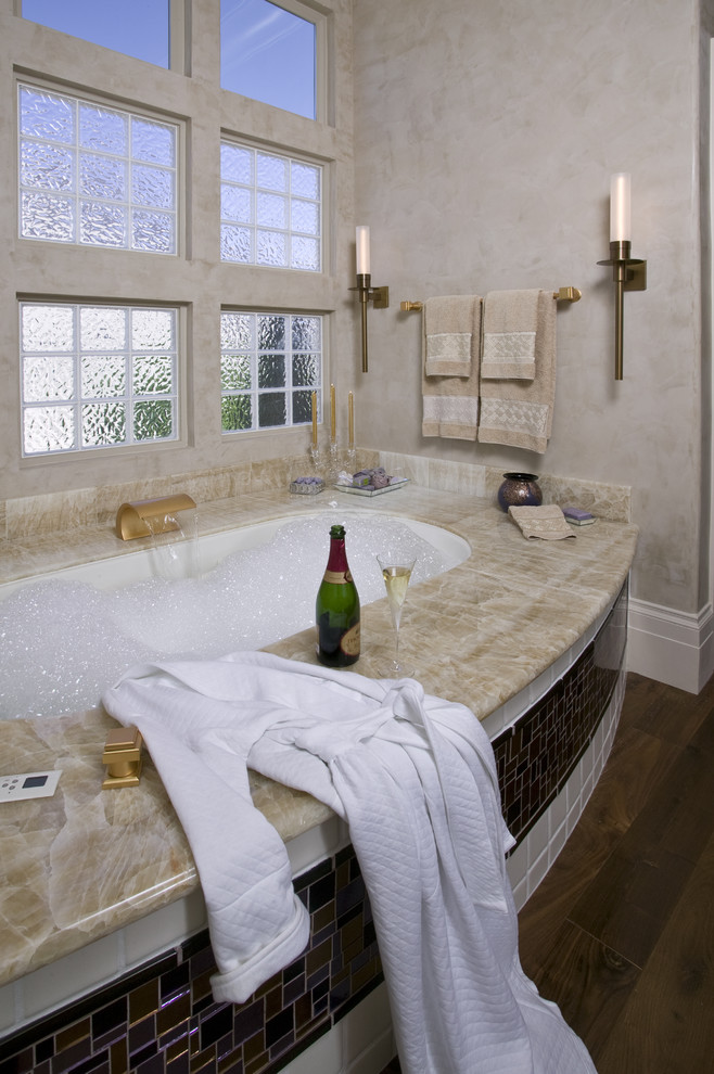 Inspiration for a mid-sized contemporary master glass tile and beige tile dark wood floor and brown floor corner shower remodel in Sacramento with an undermount sink, flat-panel cabinets, an undermount tub, beige walls, purple cabinets, a one-piece toilet, onyx countertops, a hinged shower door and beige countertops