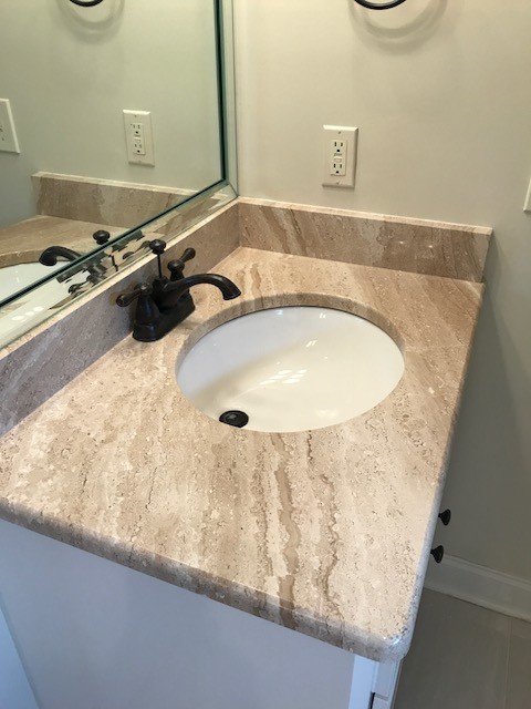 This is an example of a traditional ensuite bathroom in Jackson with white cabinets, a built-in bath, beige walls, porcelain flooring, a submerged sink, beige floors and a hinged door.