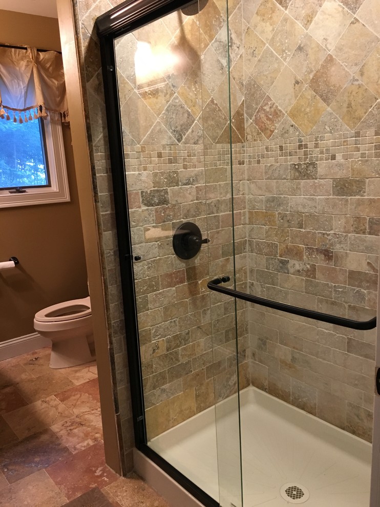 Idéer för ett mellanstort klassiskt badrum med dusch, med möbel-liknande, bruna skåp, en toalettstol med separat cisternkåpa, flerfärgad kakel, stenkakel, bruna väggar, travertin golv och granitbänkskiva