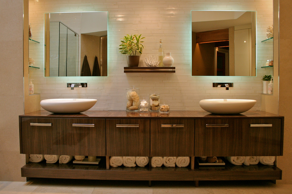 Modernes Badezimmer En Suite mit Aufsatzwaschbecken, dunklen Holzschränken, beigen Fliesen und beiger Wandfarbe in New York