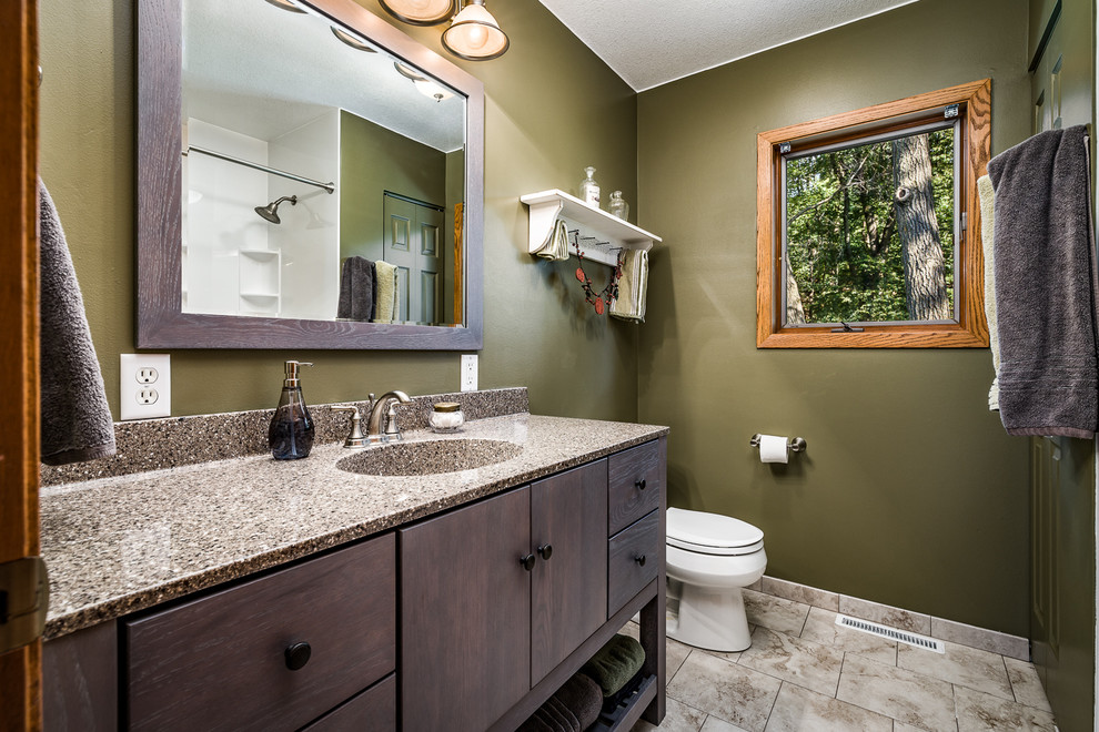 This is an example of a medium sized rustic shower room bathroom in Other with flat-panel cabinets, black cabinets, an alcove bath, a shower/bath combination, a two-piece toilet, green walls, ceramic flooring, an integrated sink, granite worktops, grey floors and a shower curtain.