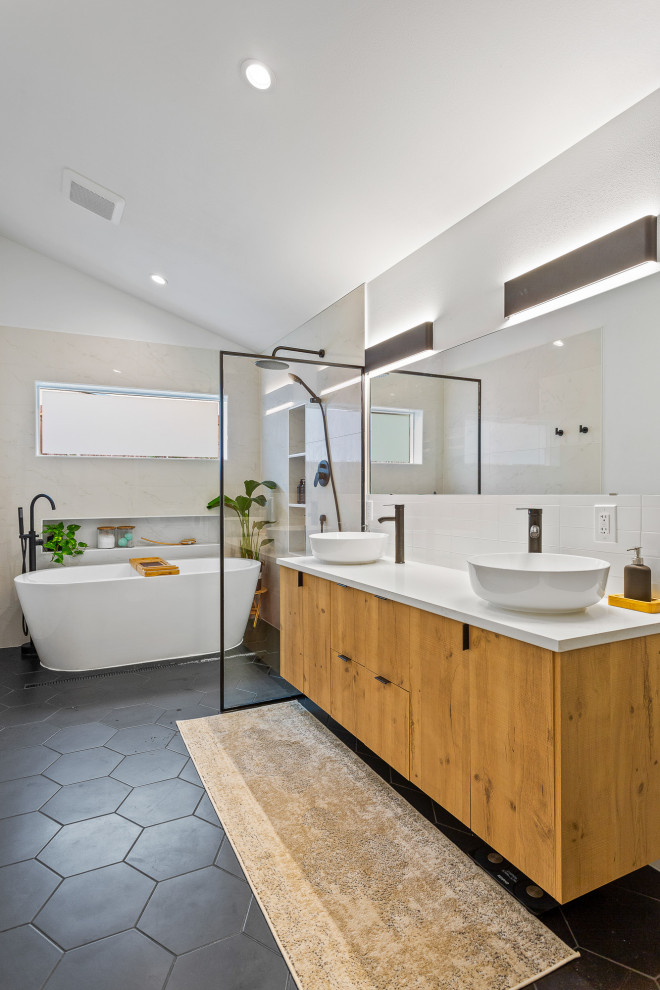 Cette image montre une grande salle de bain principale design en bois brun avec un placard à porte plane, une baignoire indépendante, un espace douche bain, un carrelage beige, un mur blanc, un sol en carrelage de porcelaine, une vasque, un sol gris, un plan de toilette blanc, une niche et meuble-lavabo suspendu.