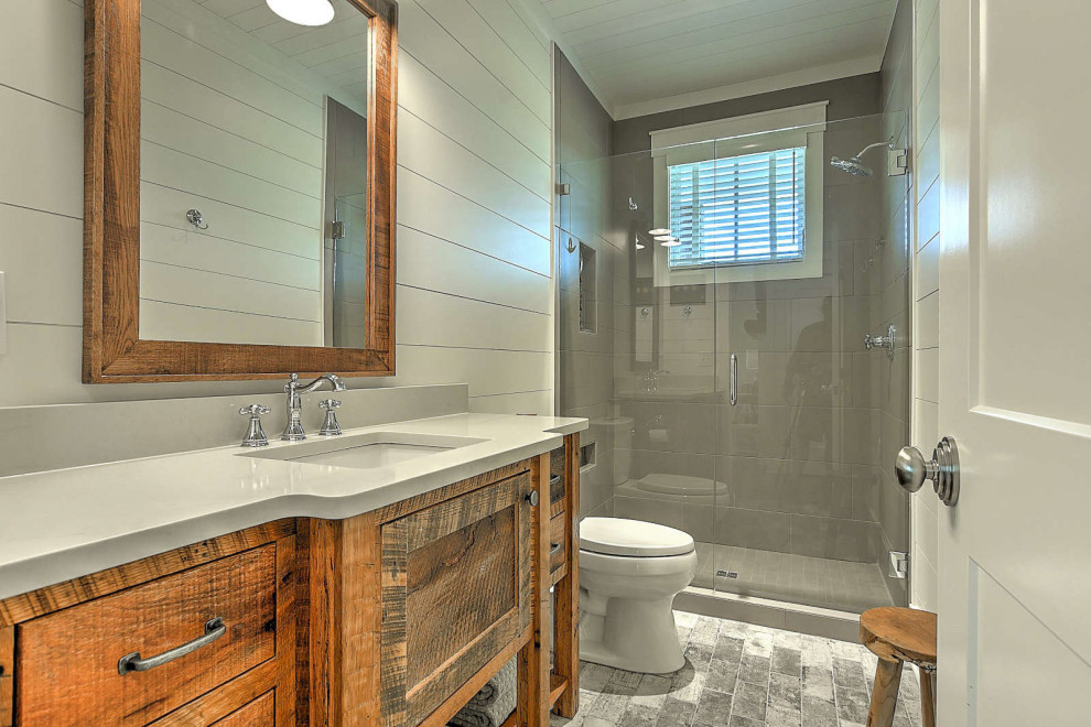 Small rustic shower room bathroom in Other with medium wood cabinets, an alcove shower, a two-piece toilet, ceramic flooring, grey floors, a hinged door, white worktops, a single sink and tongue and groove walls.