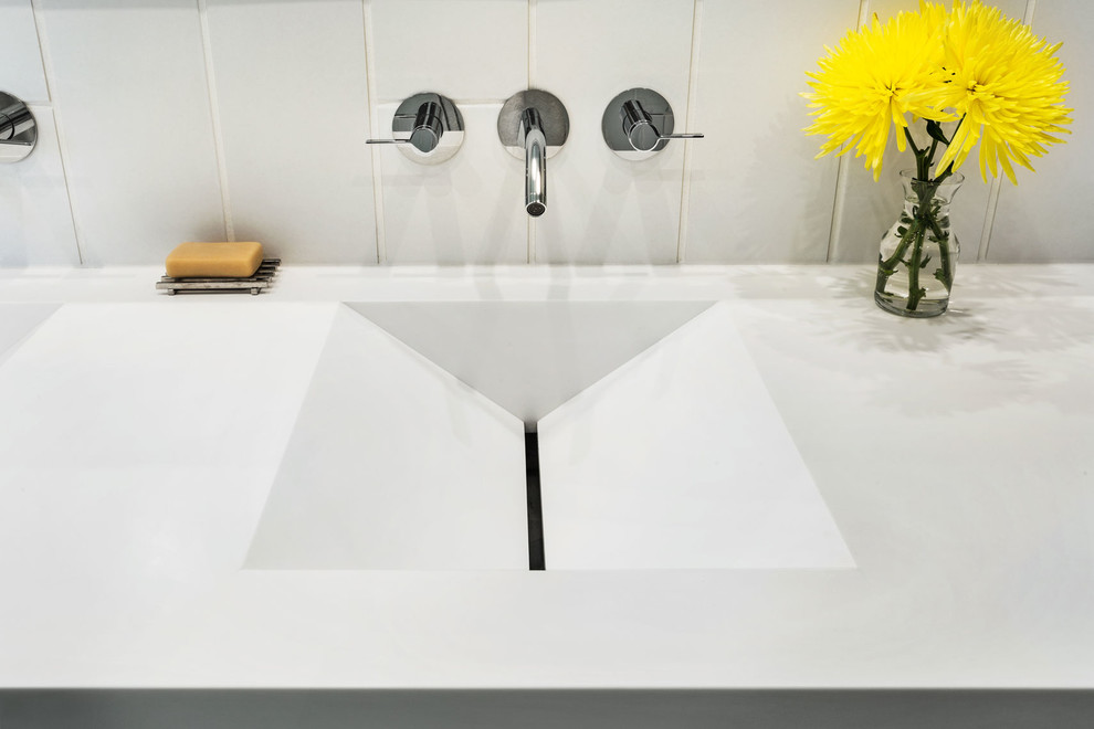 Cette image montre une salle de bain minimaliste avec un mur blanc.