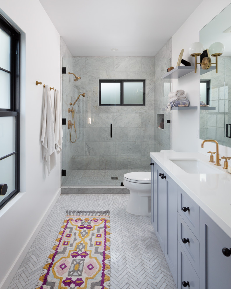 Foto på ett stort vintage vit en-suite badrum, med skåp i mellenmörkt trä, ett badkar i en alkov, vit kakel, keramikplattor, ett undermonterad handfat, bänkskiva i kvarts, skåp i shakerstil, en toalettstol med separat cisternkåpa, vita väggar och grått golv