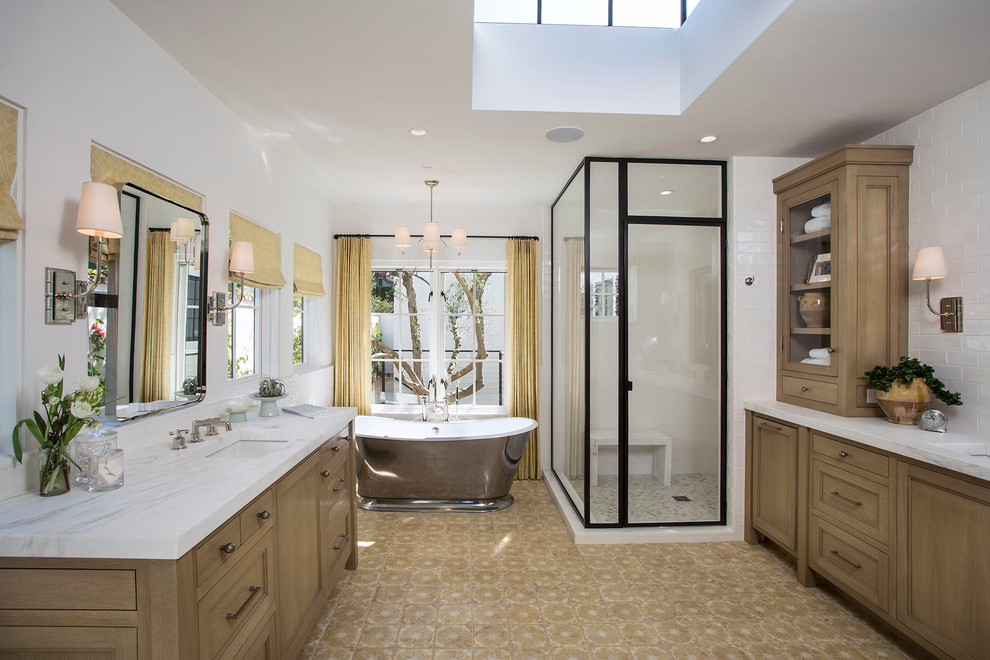 Пример оригинального дизайна: главная ванная комната в средиземноморском стиле с фасадами с утопленной филенкой, фасадами цвета дерева среднего тона, отдельно стоящей ванной, белой плиткой, белыми стенами, врезной раковиной и душем с распашными дверями