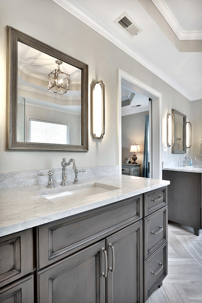 Inredning av ett klassiskt stort en-suite badrum, med luckor med infälld panel, grå skåp, ett fristående badkar, en dusch i en alkov, beige kakel, porslinskakel, beige väggar, klinkergolv i porslin, ett undermonterad handfat, marmorbänkskiva, beiget golv och dusch med gångjärnsdörr