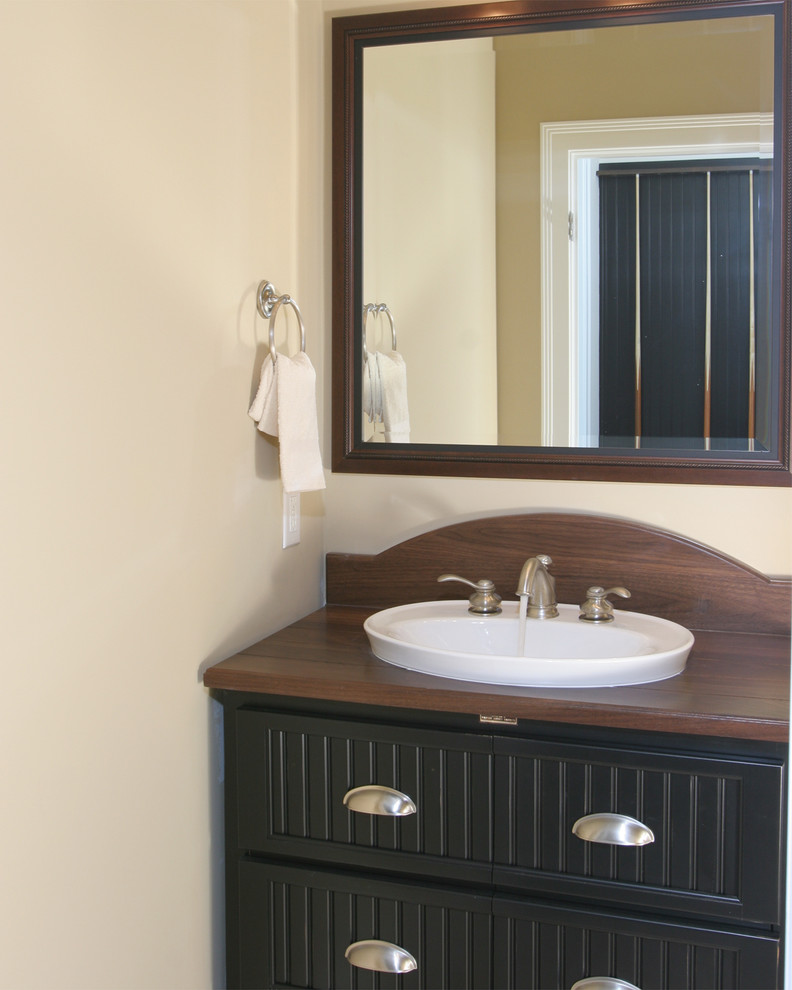 Mittelgroßes Klassisches Badezimmer mit Aufsatzwaschbecken, Schrankfronten im Shaker-Stil, schwarzen Schränken, Waschtisch aus Holz, beiger Wandfarbe und brauner Waschtischplatte in Indianapolis