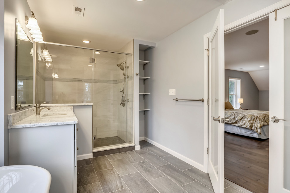 Mid-sized elegant master ceramic tile and gray floor bathroom photo in DC Metro with raised-panel cabinets, gray cabinets, a one-piece toilet, gray walls, an undermount sink, granite countertops and white countertops