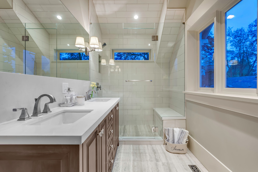 Inspiration for a mid-sized timeless master multicolored tile and ceramic tile limestone floor alcove shower remodel in Vancouver with raised-panel cabinets, brown cabinets, beige walls, an undermount sink and quartz countertops