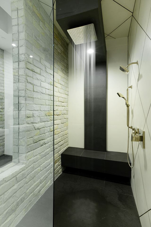 Foto på ett stort funkis en-suite badrum, med släta luckor, vita skåp, ett hörnbadkar, en öppen dusch, en toalettstol med hel cisternkåpa, vit kakel, stenkakel, svarta väggar, betonggolv, ett piedestal handfat och bänkskiva i täljsten