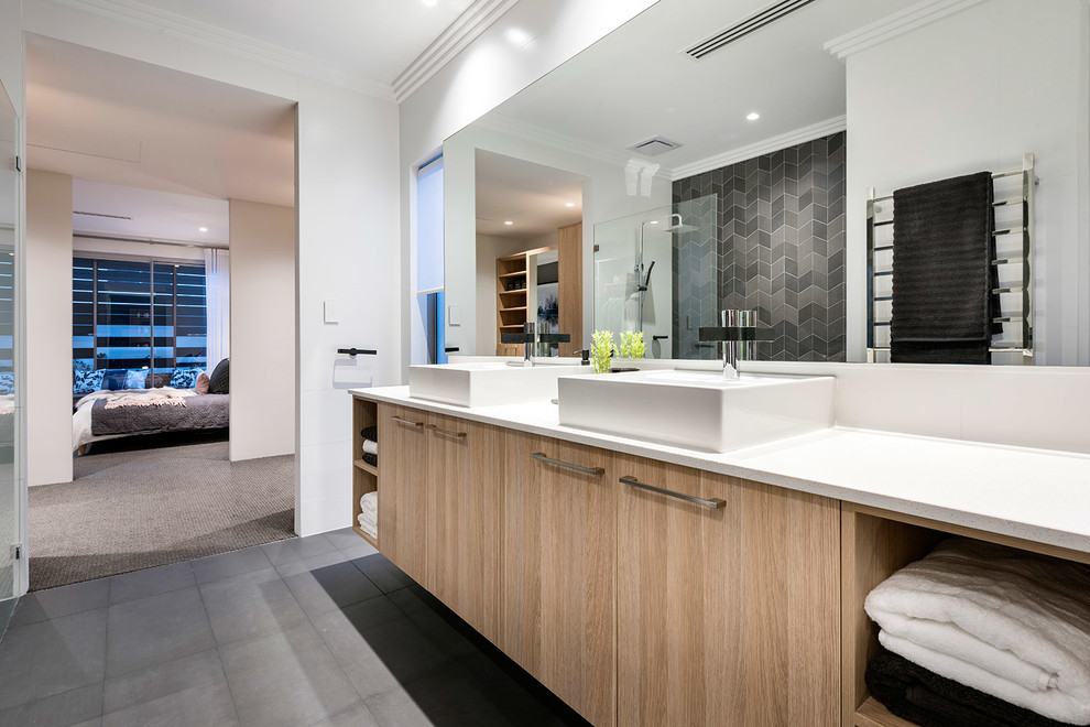 Modelo de cuarto de baño principal contemporáneo con armarios con paneles lisos, puertas de armario de madera clara, ducha abierta, baldosas y/o azulejos negros, paredes blancas, lavabo sobreencimera y encimeras blancas
