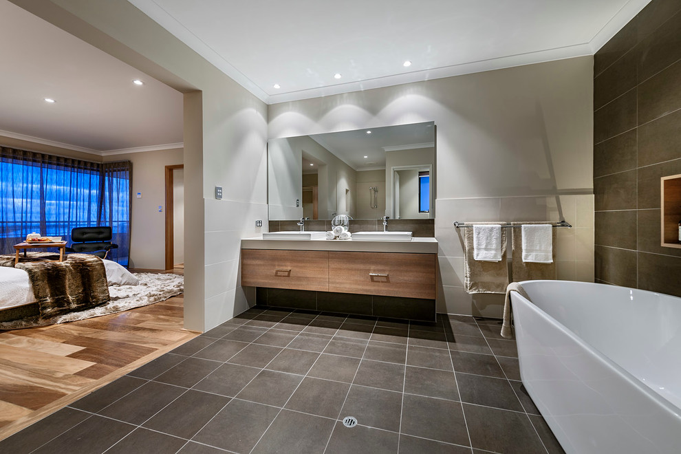 Источник вдохновения для домашнего уюта: главная ванная комната в современном стиле с настольной раковиной, плоскими фасадами, фасадами цвета дерева среднего тона, отдельно стоящей ванной, серой плиткой и серыми стенами