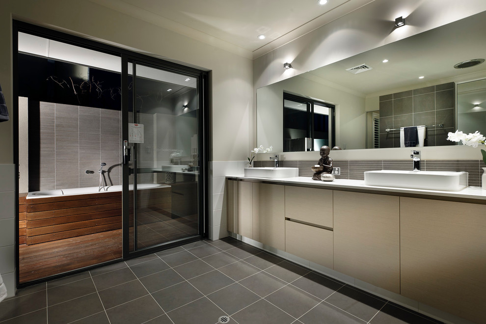 Modernes Badezimmer mit Aufsatzwaschbecken, flächenbündigen Schrankfronten, beigen Schränken, Einbaubadewanne, Duschbadewanne, grauen Fliesen und grauer Wandfarbe in Perth
