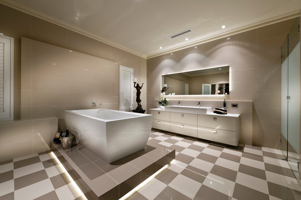 Cette photo montre une salle de bain tendance avec un placard à porte plane, des portes de placard grises, une baignoire indépendante, un carrelage gris et une douche à l'italienne.
