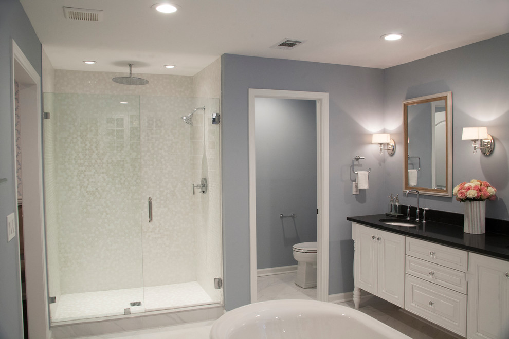 Idee per una stanza da bagno design con vasca con piedi a zampa di leone e piastrelle bianche