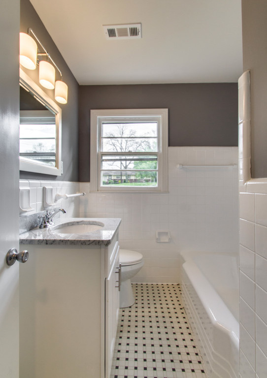 Kleines Klassisches Badezimmer mit weißen Schränken, Duschbadewanne, weißen Fliesen, grauer Wandfarbe, Keramikboden und Granit-Waschbecken/Waschtisch in Nashville