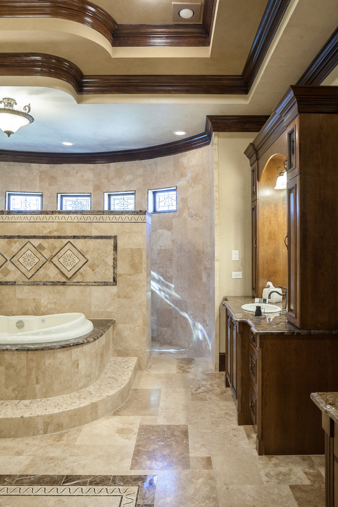 Huge elegant master beige tile and stone tile travertine floor bathroom photo in Houston with a drop-in sink, raised-panel cabinets, medium tone wood cabinets, marble countertops, a two-piece toilet and beige walls