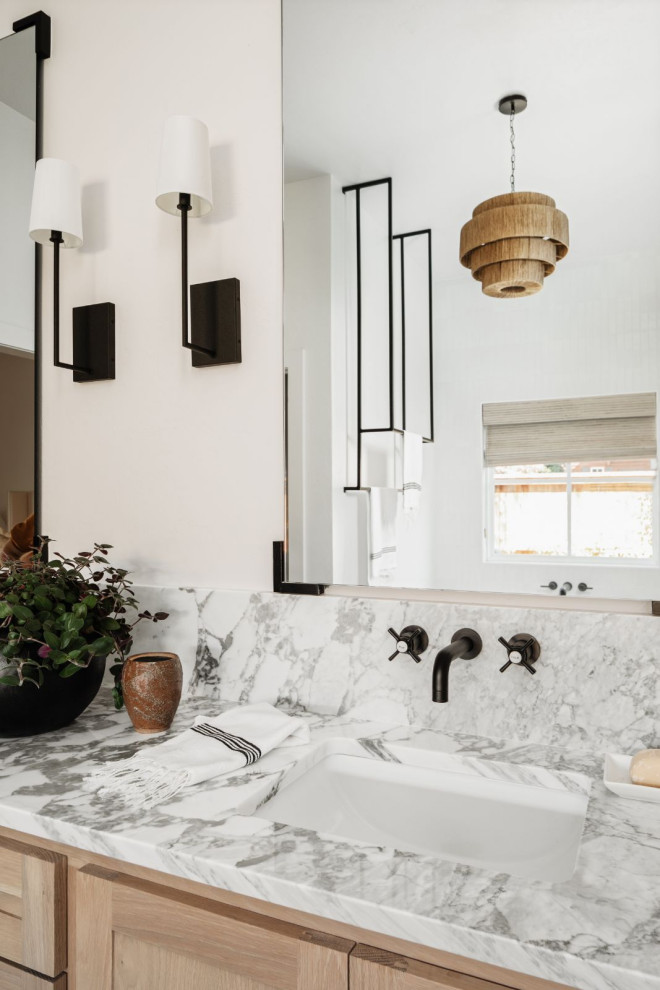 Inredning av ett klassiskt stort vit vitt en-suite badrum, med skåp i shakerstil, skåp i ljust trä, ett fristående badkar, en dubbeldusch, en toalettstol med hel cisternkåpa, vit kakel, porslinskakel, vita väggar, klinkergolv i porslin, ett väggmonterat handfat, marmorbänkskiva, grått golv och dusch med gångjärnsdörr