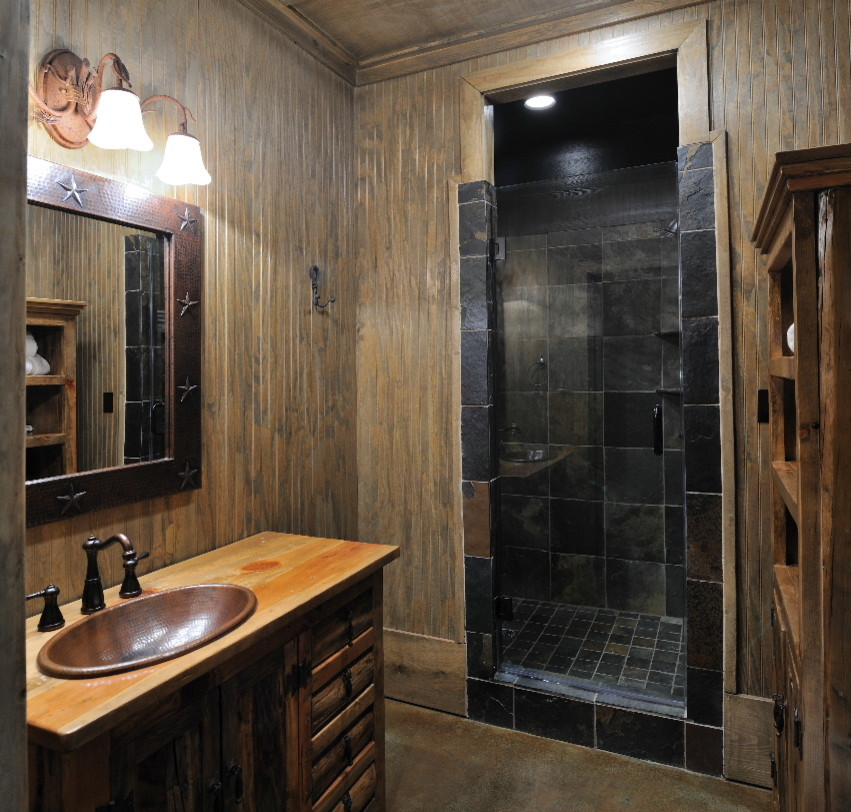 Foto på ett litet vintage badrum med dusch, med luckor med upphöjd panel, skåp i mellenmörkt trä, träbänkskiva, brun kakel, cementkakel, en dusch i en alkov, en toalettstol med separat cisternkåpa, ett nedsänkt handfat, bruna väggar och betonggolv