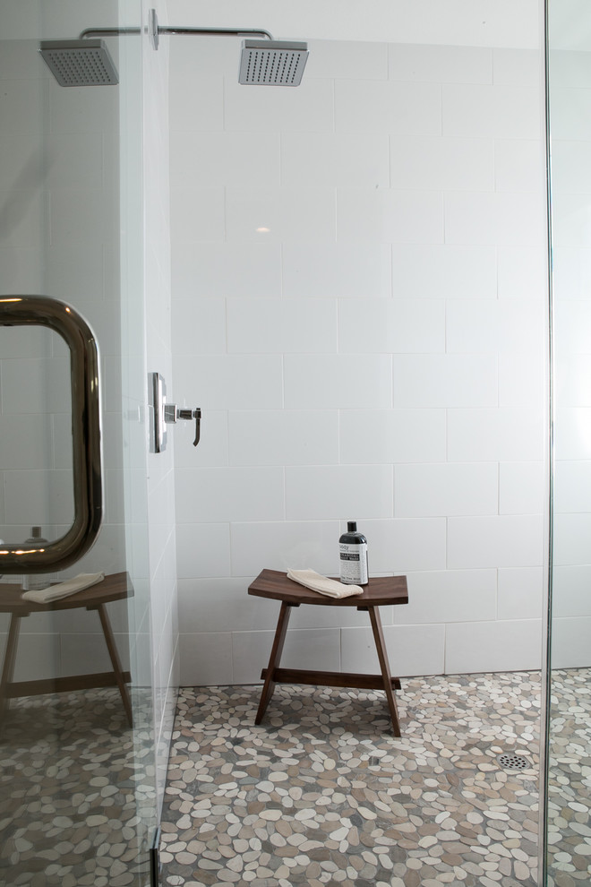 Ispirazione per una stanza da bagno moderna con doccia alcova, piastrelle bianche, piastrelle in ceramica, pavimento con piastrelle di ciottoli, pavimento marrone e porta doccia a battente