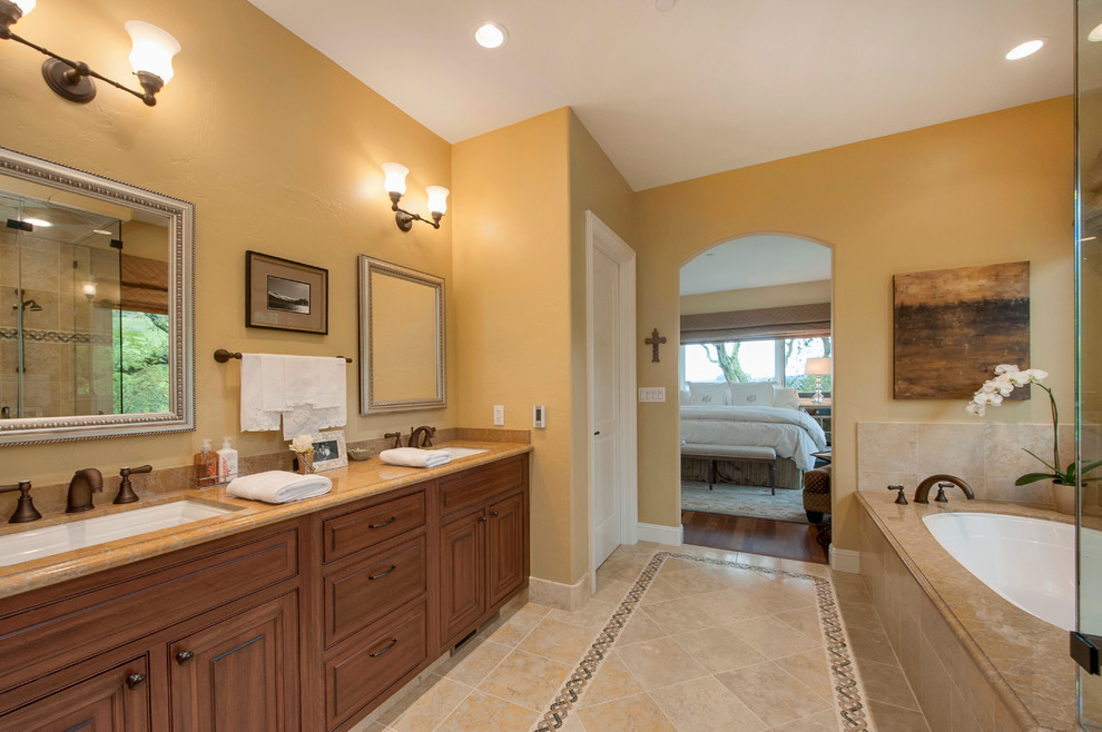 Cette photo montre une salle de bain principale moderne en bois foncé de taille moyenne avec un lavabo encastré, un placard avec porte à panneau surélevé, un plan de toilette en marbre, une baignoire encastrée, une douche d'angle, WC à poser, un carrelage multicolore, un carrelage de pierre, un mur jaune et un sol en travertin.