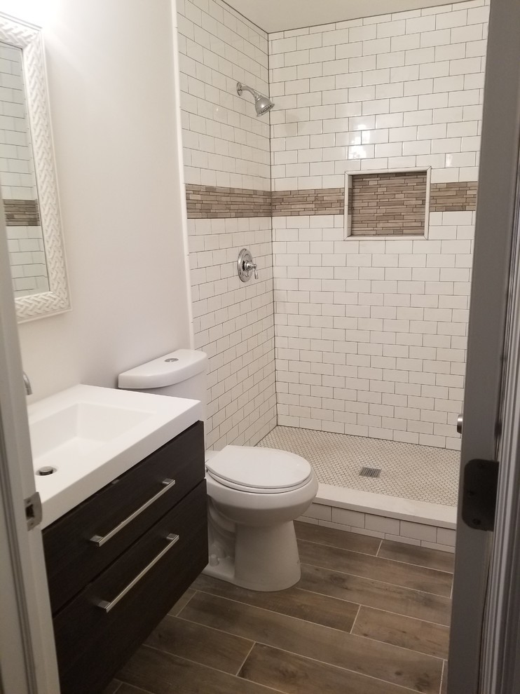 Small contemporary shower room bathroom in Philadelphia with flat-panel cabinets, dark wood cabinets, a walk-in shower, a two-piece toilet, white tiles, metro tiles, white walls, ceramic flooring, a wall-mounted sink, brown floors, a shower curtain and white worktops.