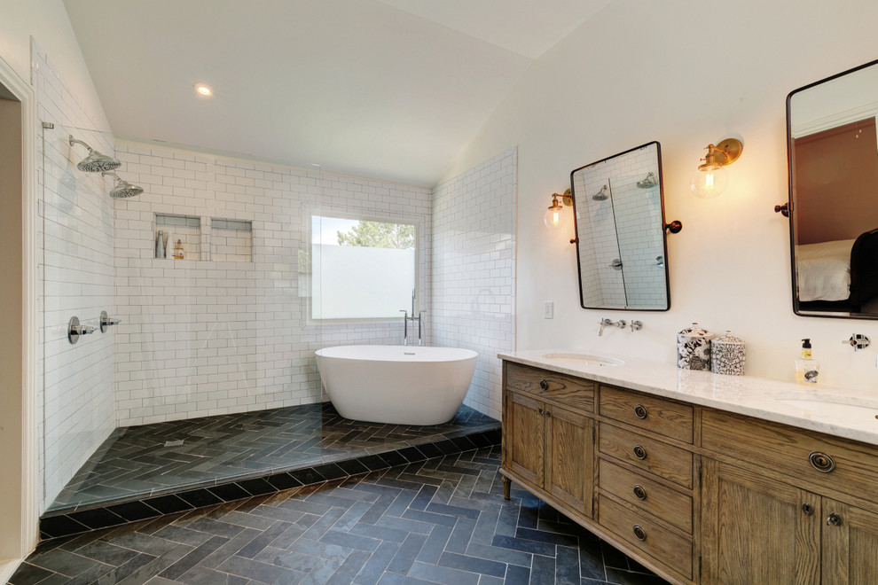 Inspiration for a large farmhouse ensuite bathroom in Atlanta with a freestanding bath, a double shower, a one-piece toilet, white tiles, metro tiles, white walls, cement flooring, a console sink, marble worktops, black floors, an open shower and white worktops.