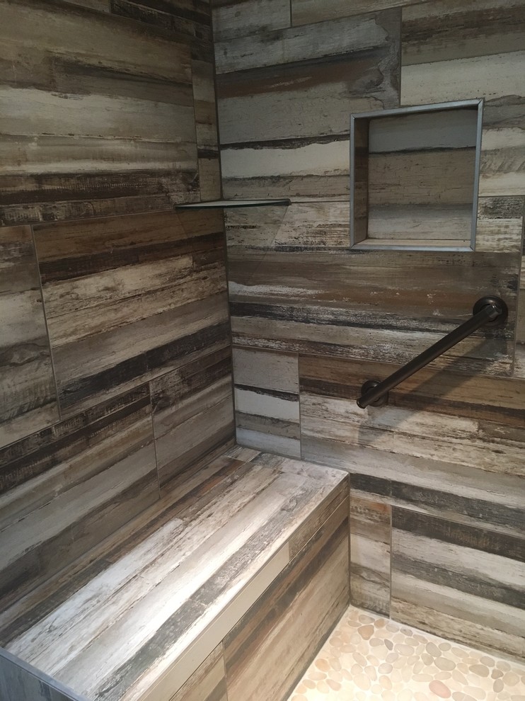 Photo of a medium sized traditional shower room bathroom in Nashville with a corner shower, brown tiles, porcelain tiles, brown walls, pebble tile flooring, beige floors and an open shower.