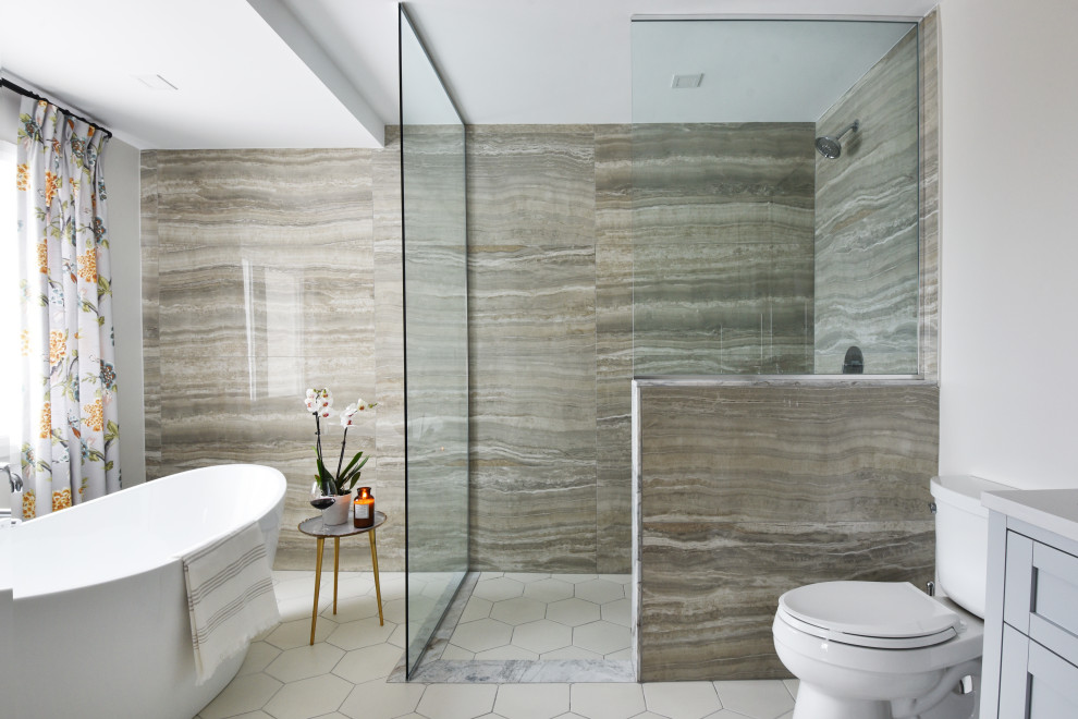 Bild på ett mellanstort vintage grå grått en-suite badrum, med grå skåp, ett fristående badkar, en kantlös dusch, en toalettstol med separat cisternkåpa, grå kakel, porslinskakel, vita väggar, klinkergolv i porslin, beiget golv och med dusch som är öppen