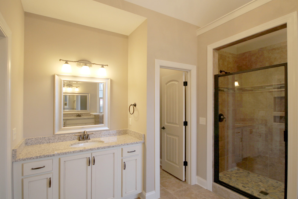 Exemple d'une grande salle de bain principale craftsman en bois clair avec un lavabo encastré, un placard à porte plane, un plan de toilette en granite, une baignoire posée, une douche double, WC à poser, un carrelage beige, des carreaux de céramique, un mur beige et un sol en carrelage de céramique.
