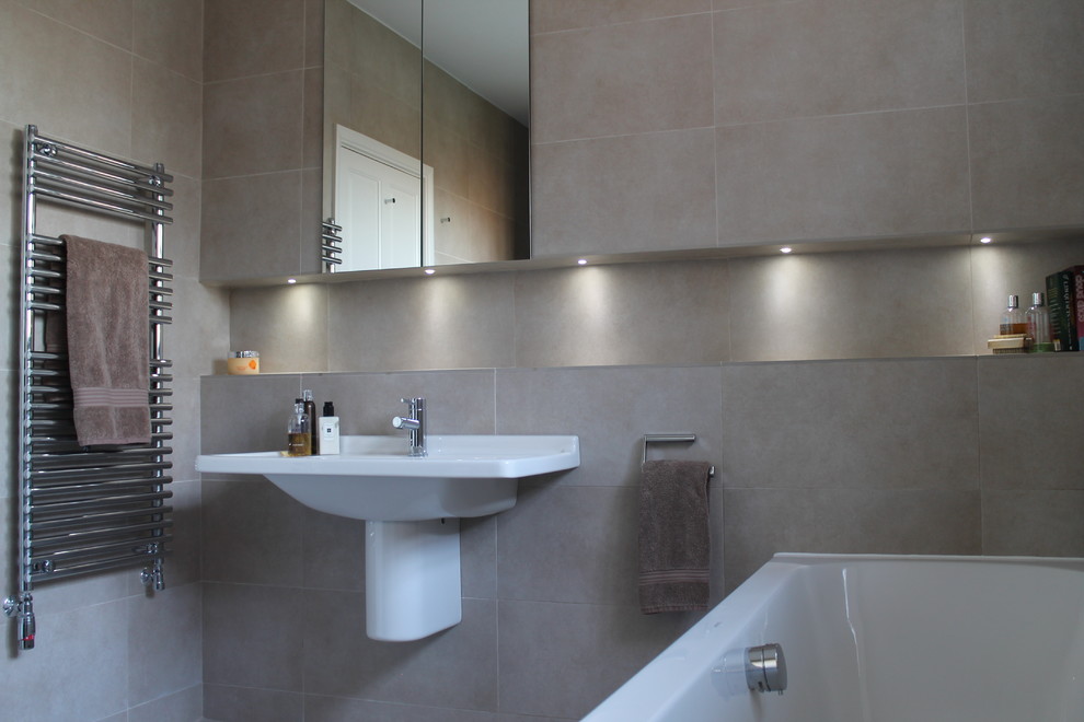This is an example of a medium sized contemporary ensuite bathroom in Other with a wall-mounted sink, a corner bath, a walk-in shower, a wall mounted toilet, beige tiles, porcelain tiles and porcelain flooring.