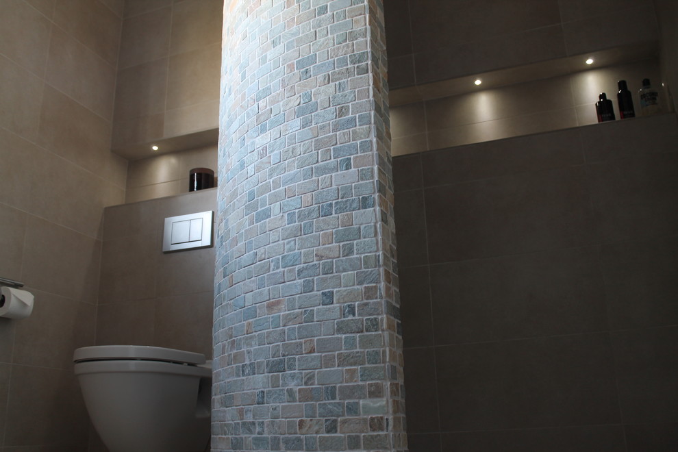 Ejemplo de cuarto de baño principal contemporáneo de tamaño medio con lavabo suspendido, bañera esquinera, ducha abierta, sanitario de pared, baldosas y/o azulejos beige, baldosas y/o azulejos de porcelana y suelo de baldosas de porcelana
