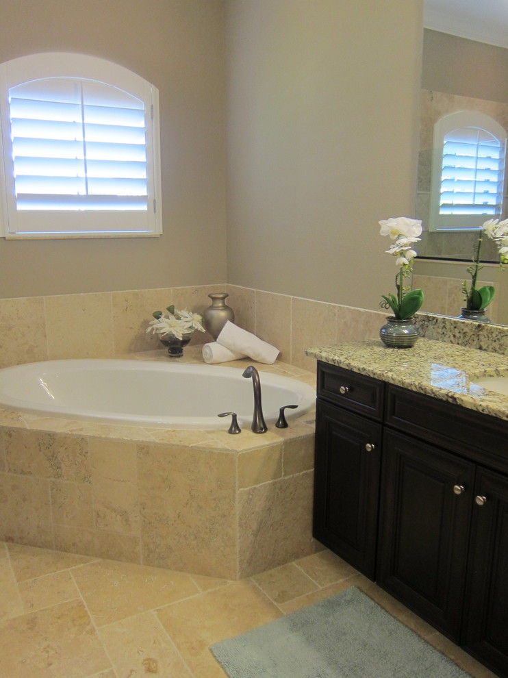 Mittelgroßes Klassisches Badezimmer En Suite mit profilierten Schrankfronten, dunklen Holzschränken, beiger Wandfarbe, Kalkstein, Unterbauwaschbecken und Granit-Waschbecken/Waschtisch in Miami