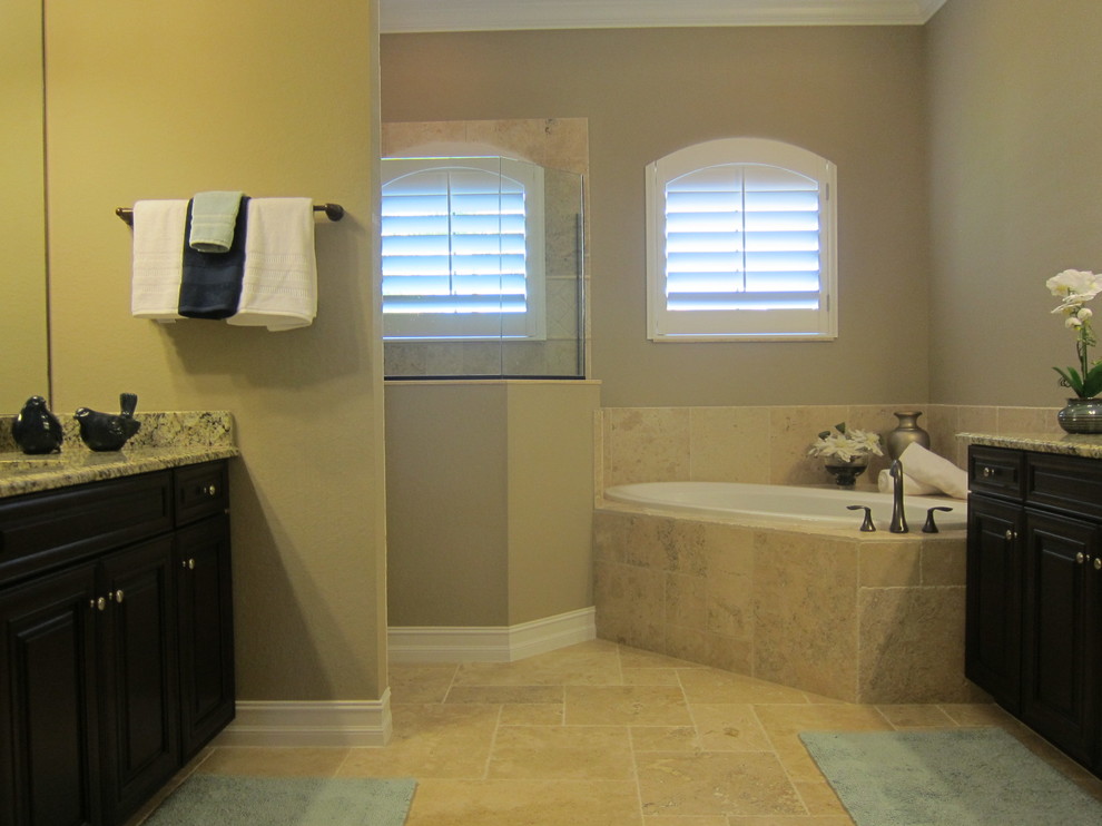 Mid-sized elegant master limestone floor bathroom photo in Miami with raised-panel cabinets, dark wood cabinets, beige walls, an undermount sink and granite countertops