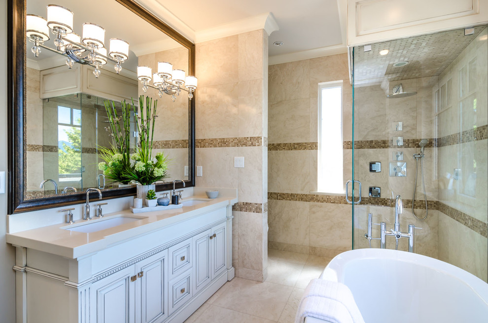Inredning av ett klassiskt en-suite badrum, med luckor med upphöjd panel, grå skåp, ett fristående badkar, en hörndusch, beige kakel, brun kakel, beige väggar och ett undermonterad handfat