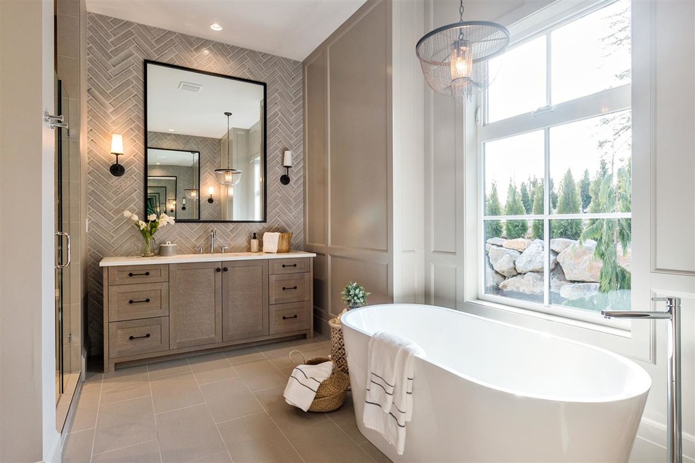 Photo of a traditional bathroom in Vancouver with shaker cabinets, medium wood cabinets, a freestanding bath, a corner shower, grey tiles, white walls, beige floors, a hinged door and white worktops.